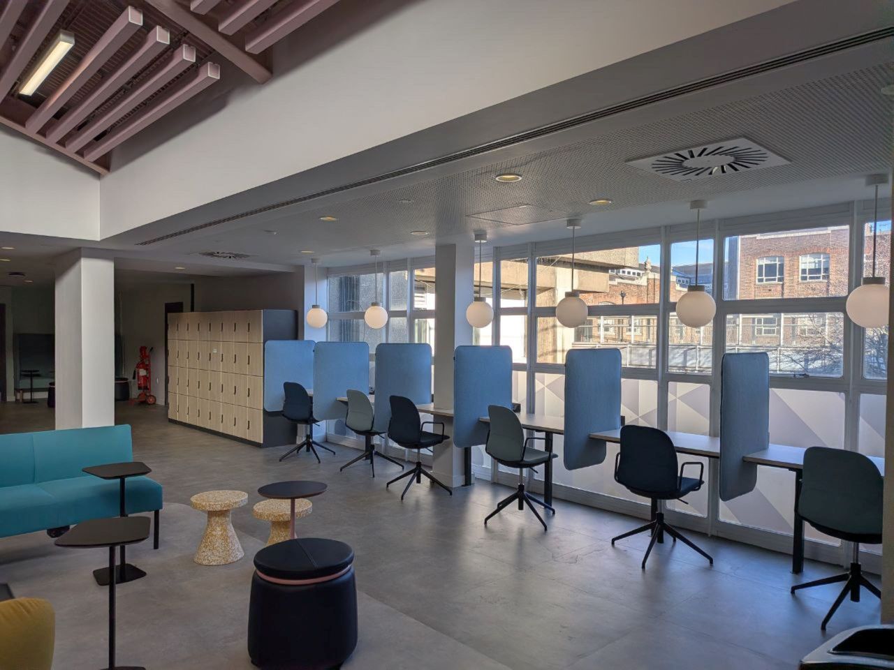 Spacious contemporary office interior in London featuring flexible seating, natural light, and a minimalist design.